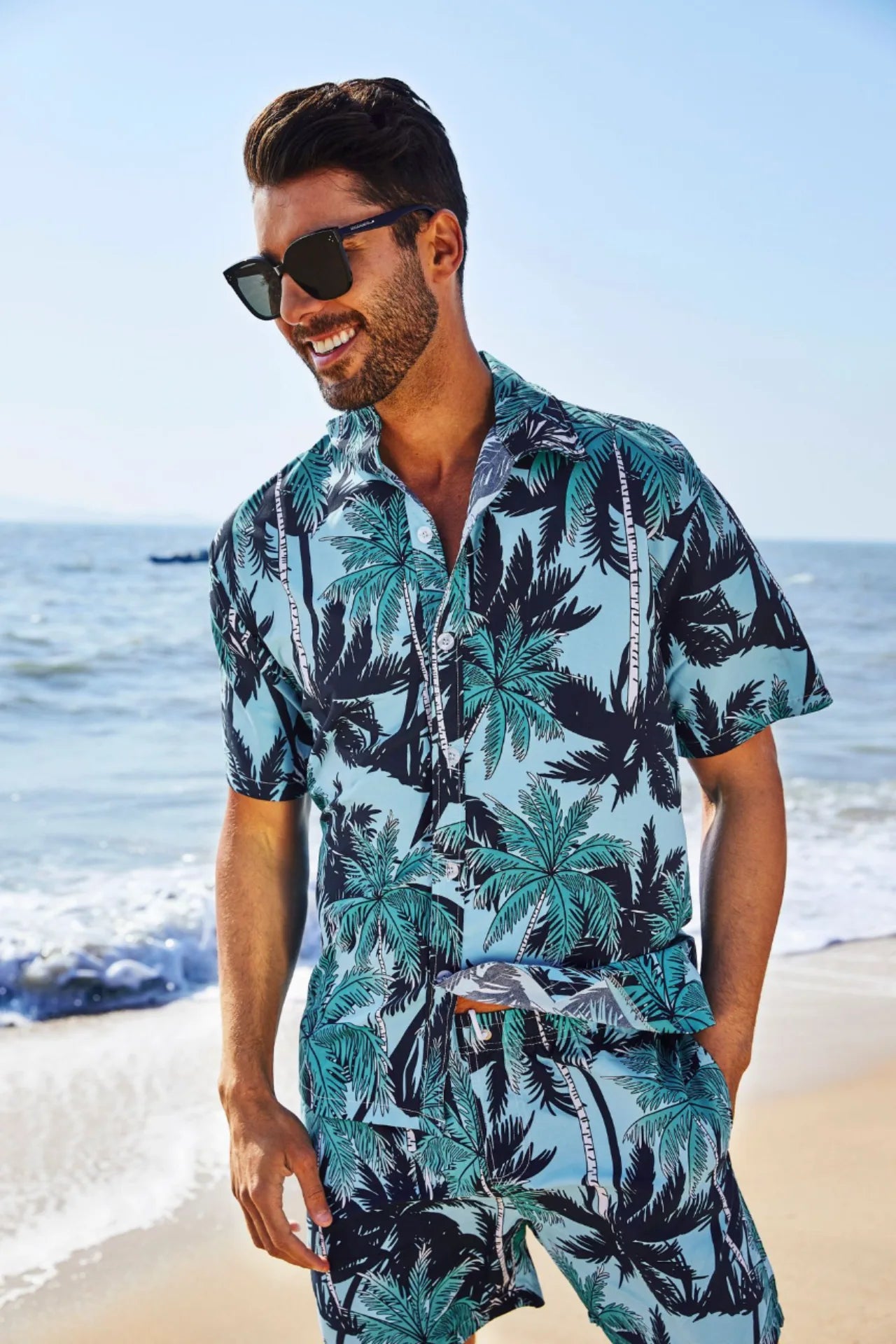 Conjunto de playa azul con estampado de palmeras para hombre, ideal para vacaciones y días de verano. Camisa de manga corta y pantalón corto a juego.