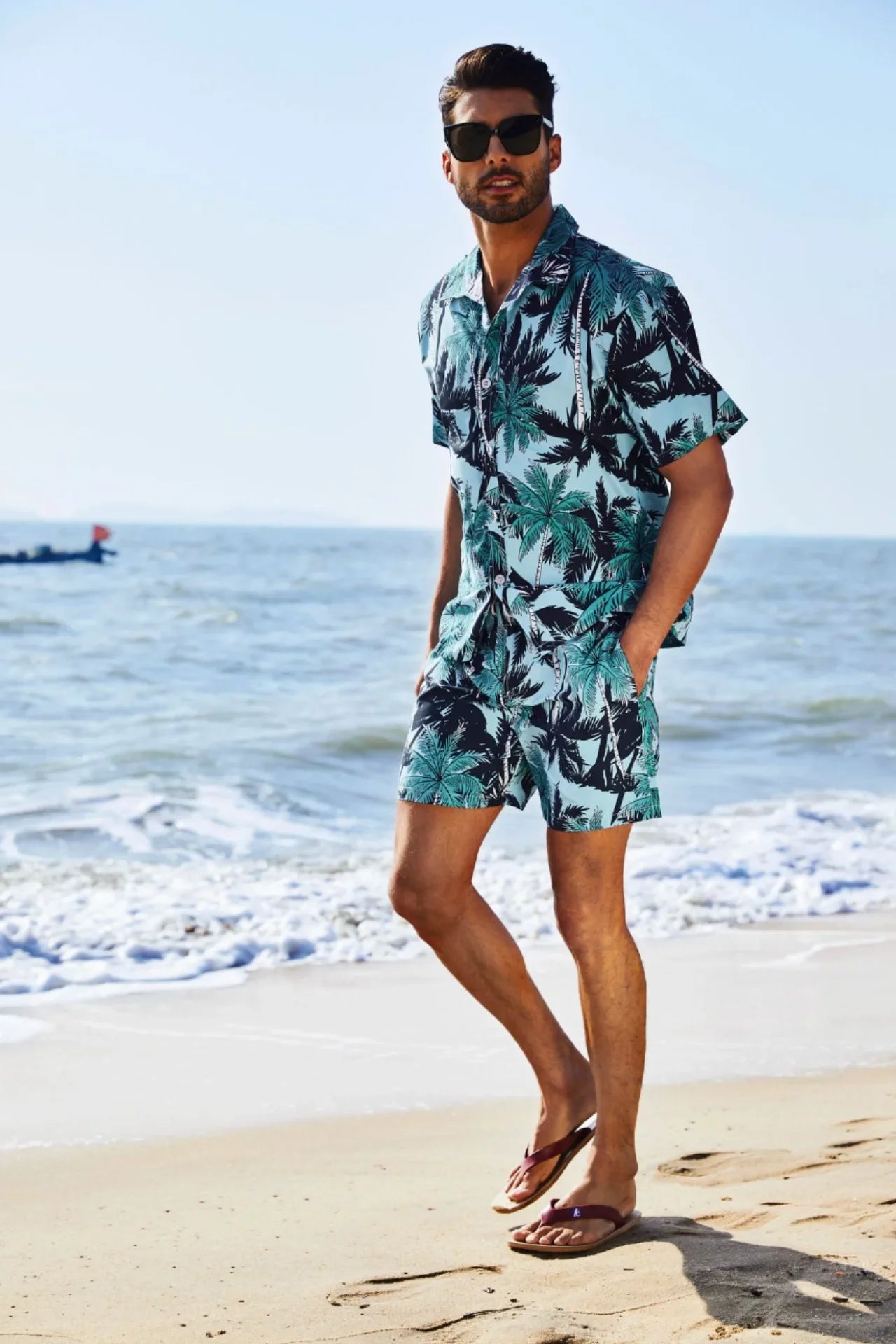 Conjunto de playa azul con estampado de palmeras para hombre, ideal para vacaciones y días de verano. Camisa de manga corta y pantalón corto a juego.