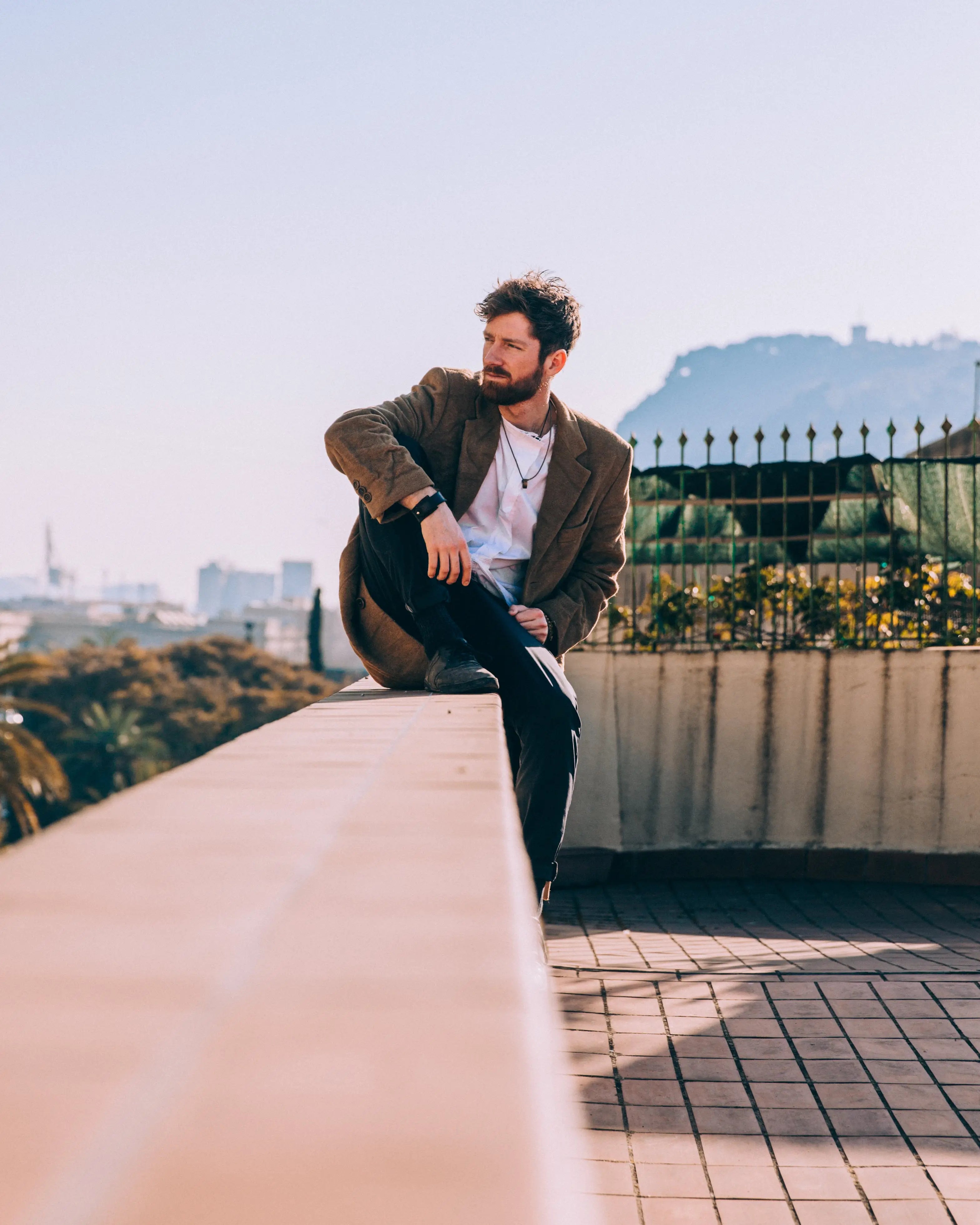 man-sitting-comfortably-on-roof-ledge.webp